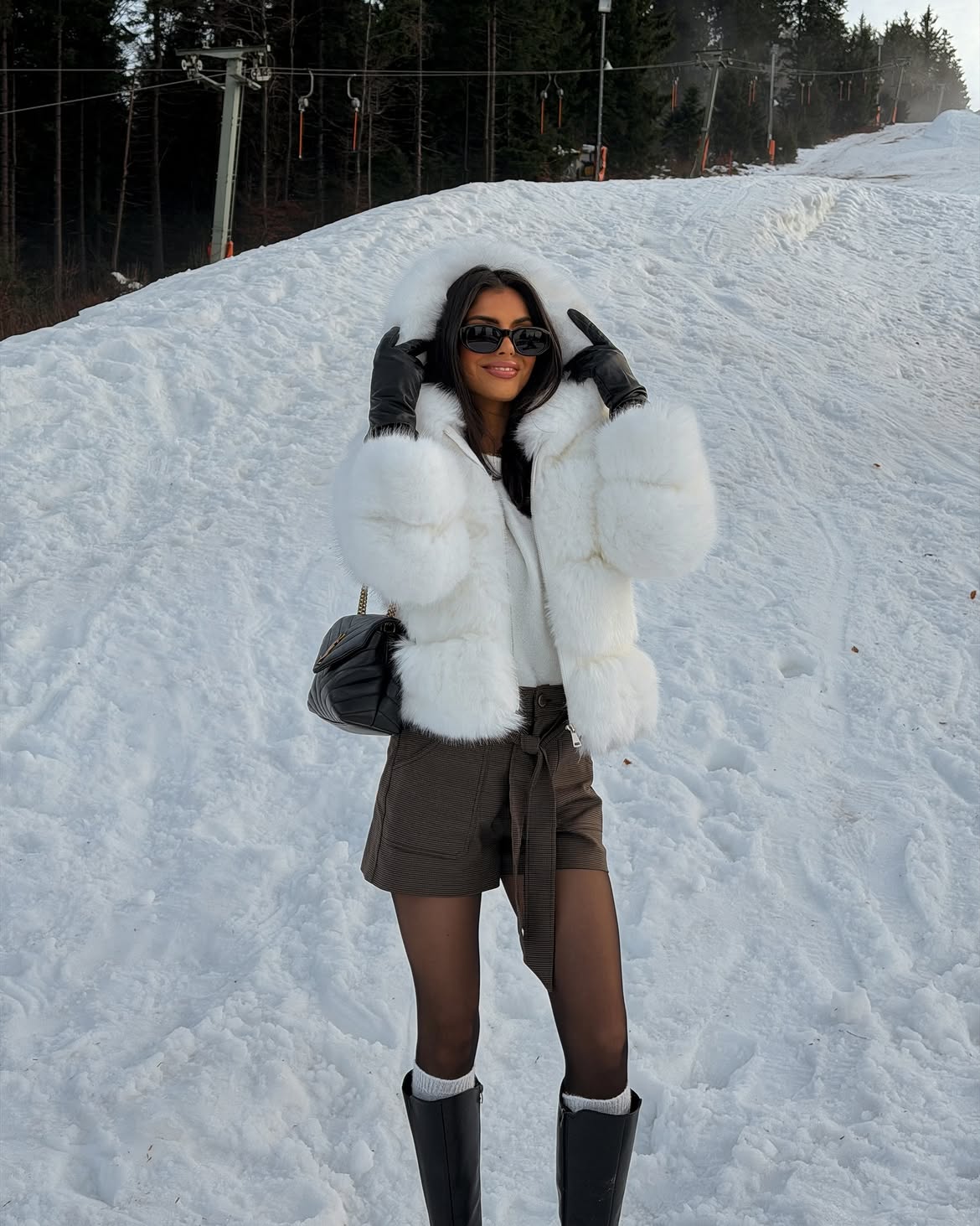 White Faux Fur Hooded Jacket With Dark Shorts And Boots