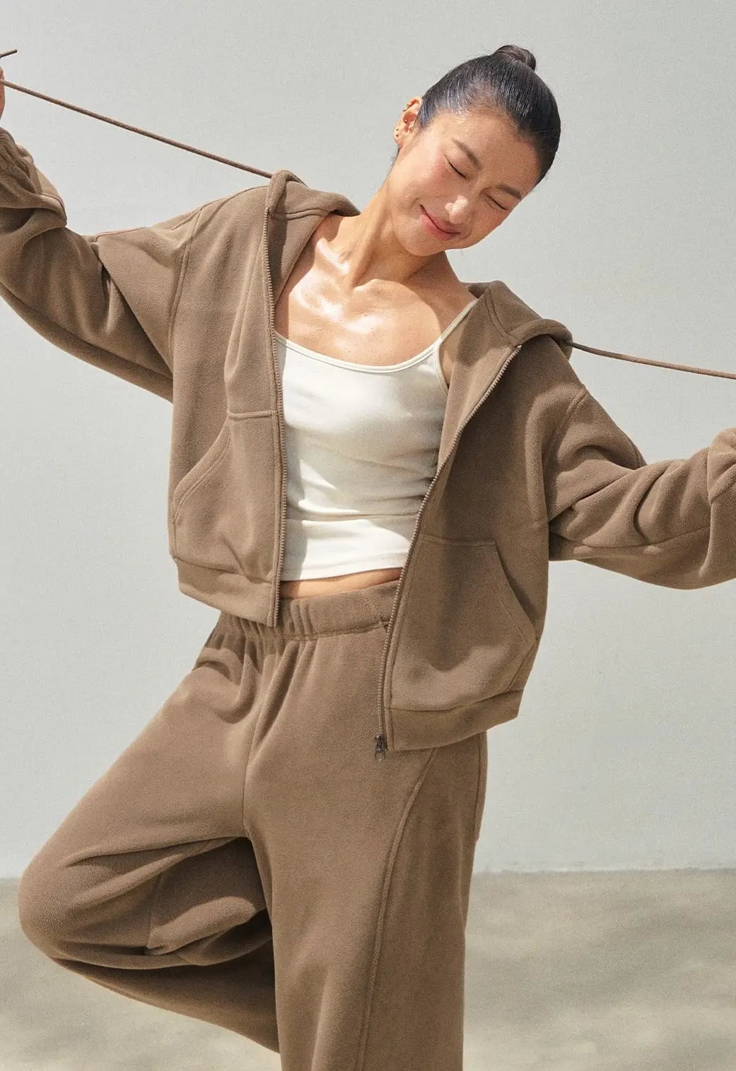 Cropped Zip Hoodie Layered Over Tank, Close-Up Take Cropped Zip Hoodie Layered Over Tank, Close-Up Take — Brown Sweatpants Outfit