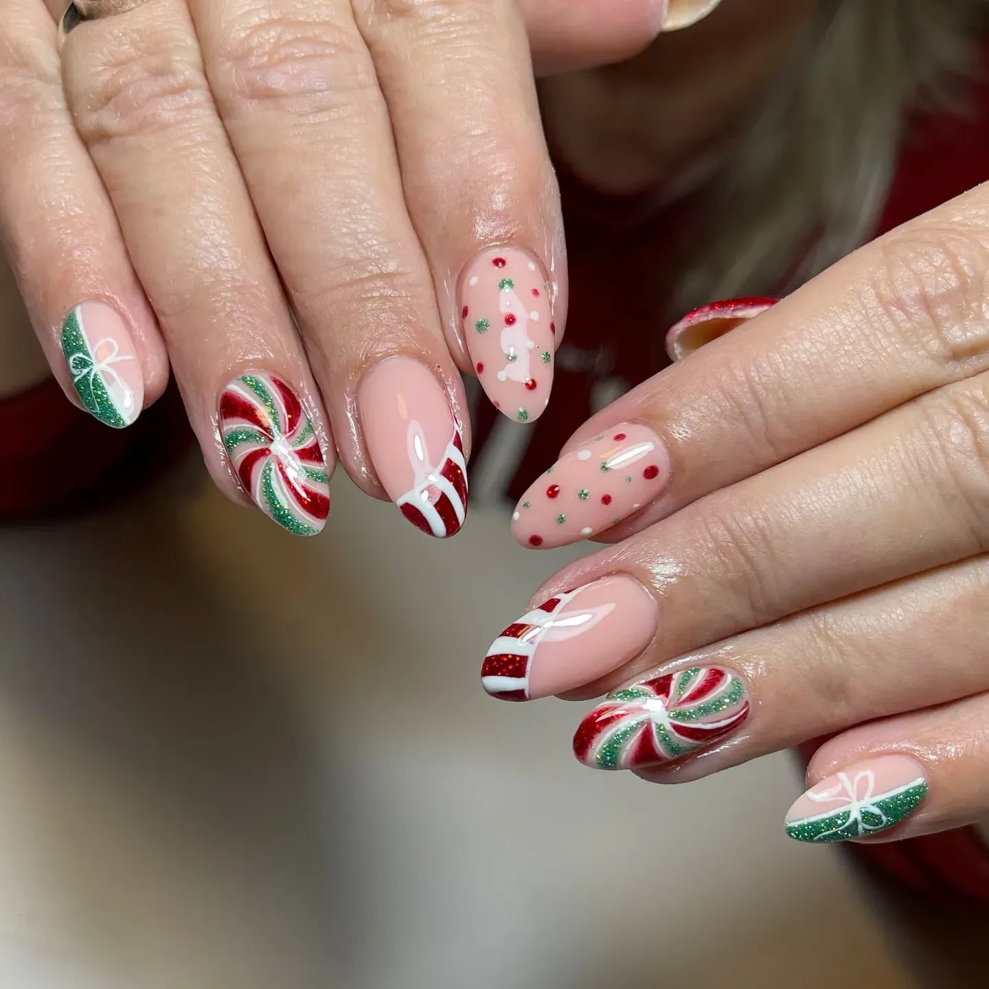 Medium Almond Nude With Candy Cane Stripes and Glitter Bows Medium Almond Nude With Candy Cane Stripes and Glitter Bows — Christmas Acrylic Nails