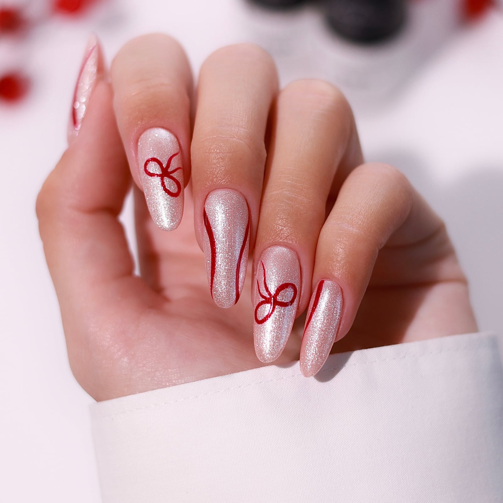 Red Bow Pearlescent Pink Medium Almond Nails, Close-Up Take Red Bow Pearlescent Pink Medium Almond Nails, Close-Up Take — Christmas Nails