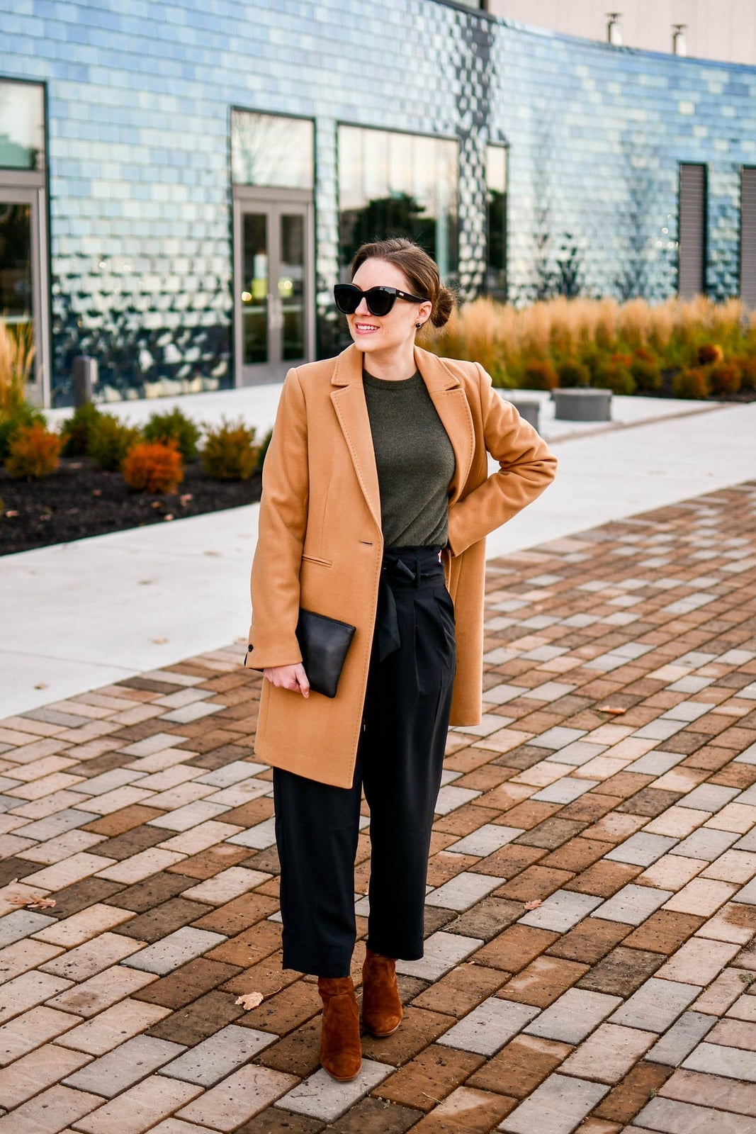 Camel Coat Over Green Top And Black Trousers — Christmas Party Outfits Casual