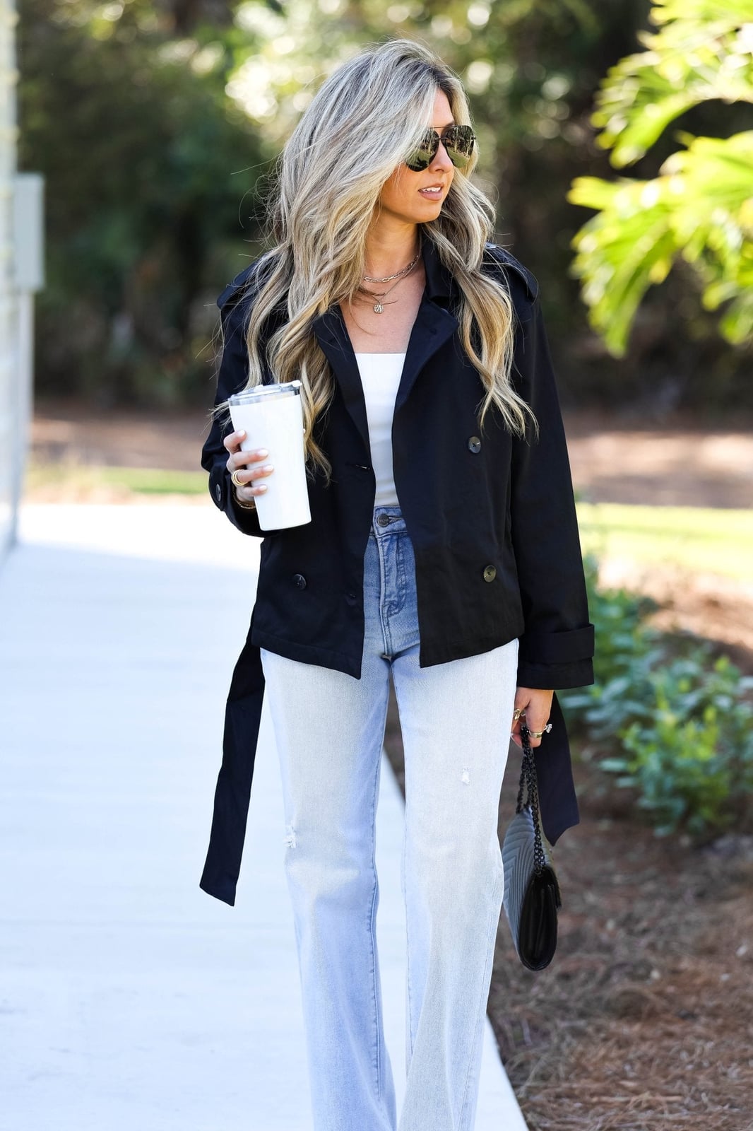 Black Cropped Jacket With Tie Belt Over White Tank And Blue Jeans — Cropped Jacket Outfits