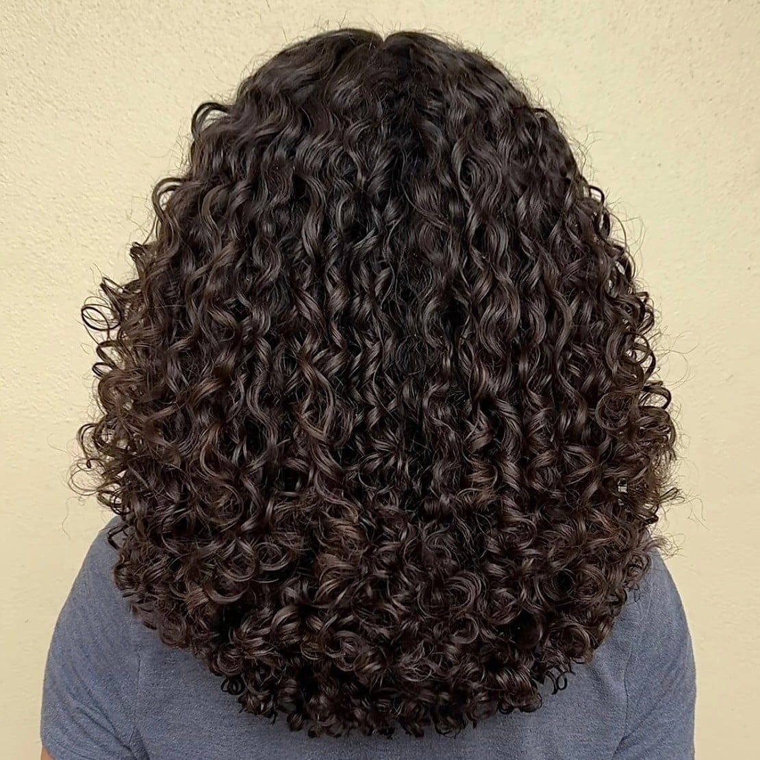 Thick Curly Collarbone Layers With Uniform Curls — Curly Hair Down