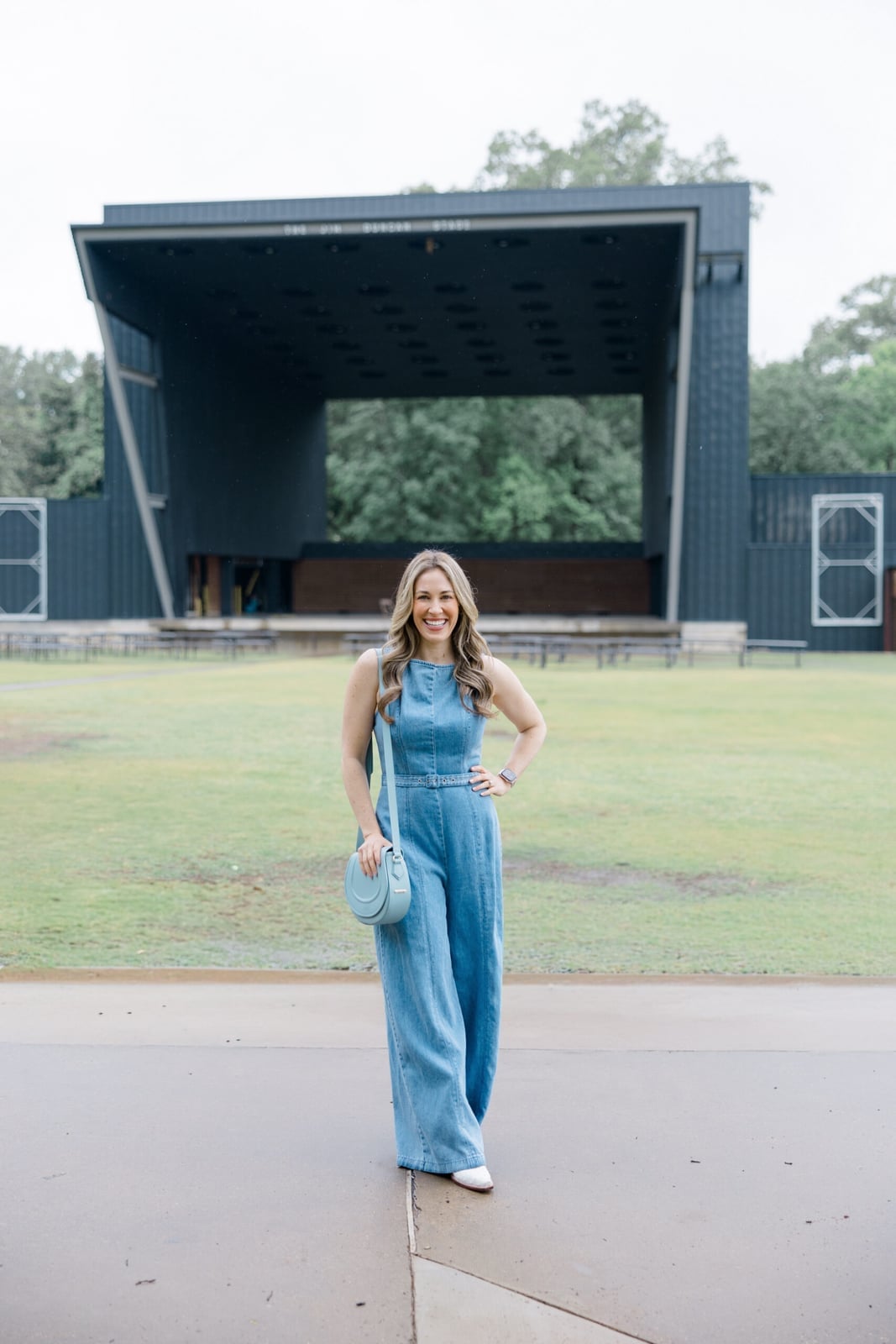 Denim Jumpsuit with Crossbody Bag and White Sneakers, Close-Up Take — Cute Concert Outfit