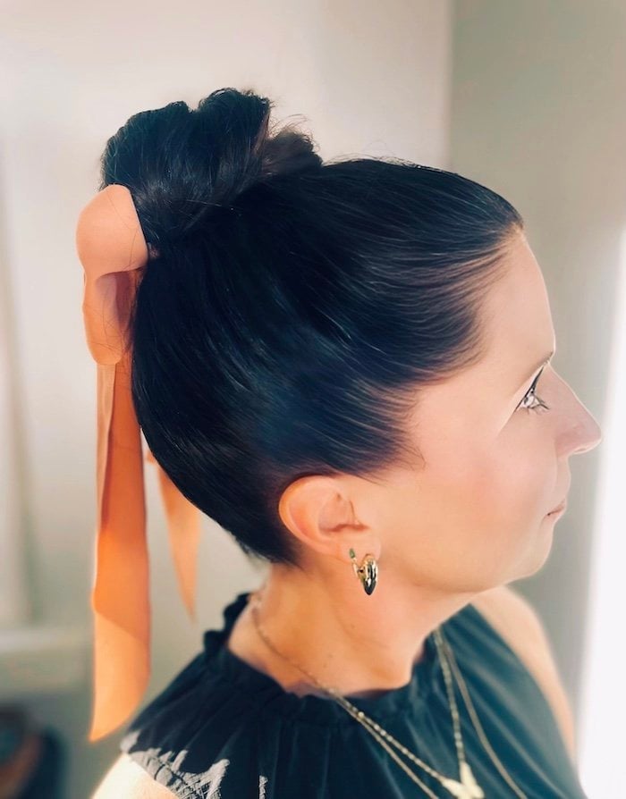 Sleek Black High Bun With Peach Ribbon — Dance Hair