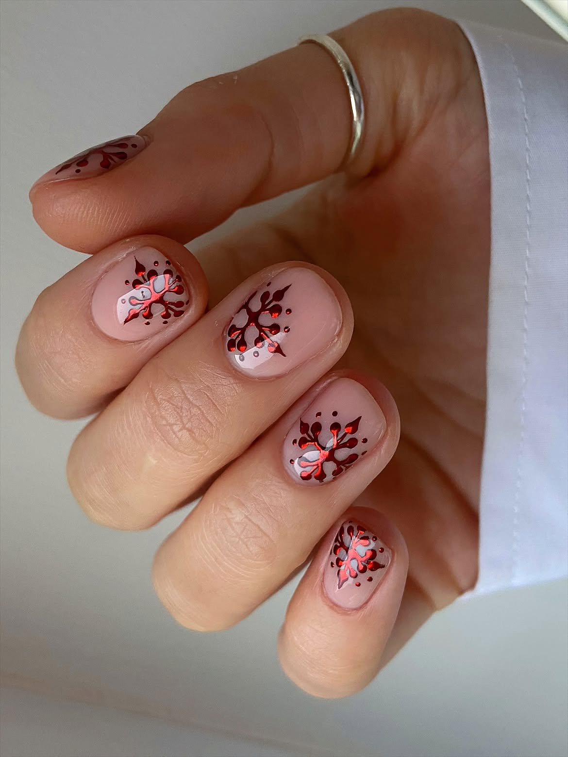Glossy Nude Short Nails With Metallic Red Snowflakes