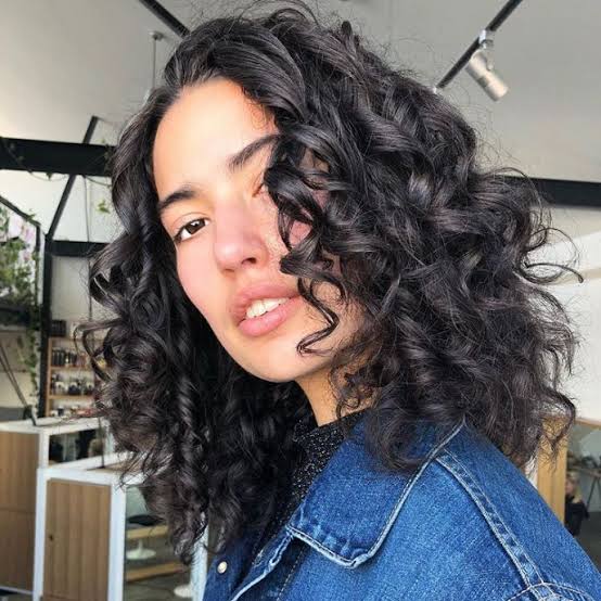 Collarbone Curls With Caramel Highlights, Layers — Medium Curly Hair