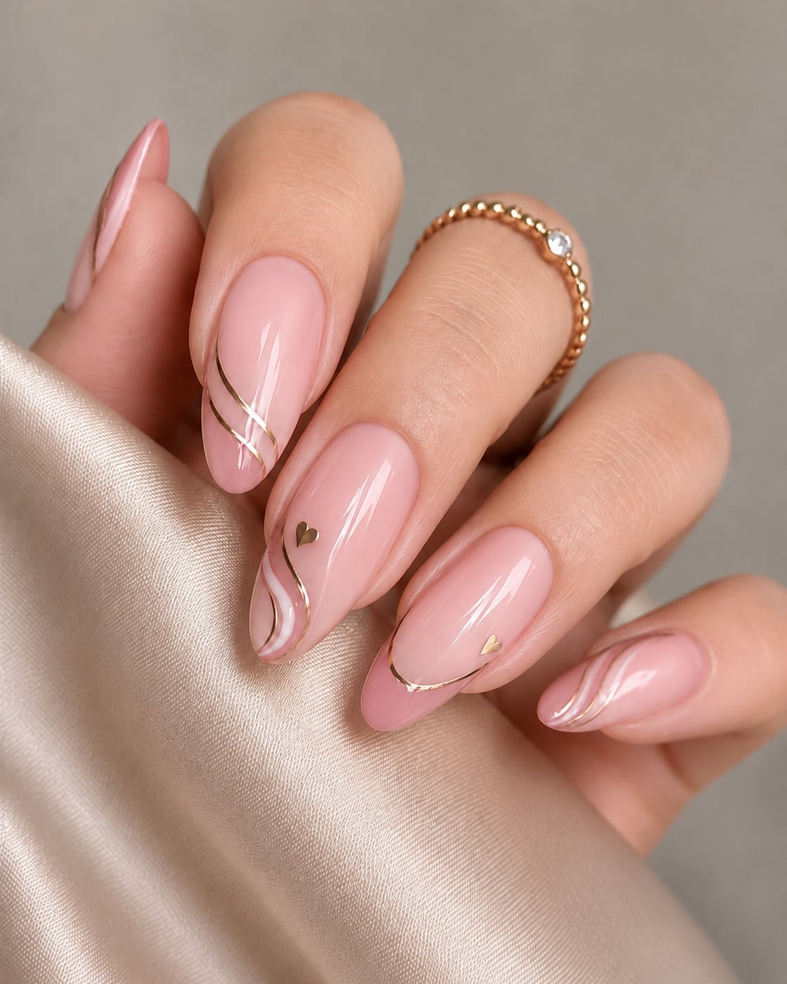 Nude Pink Almond Nails with Gold Lines and Hearts
