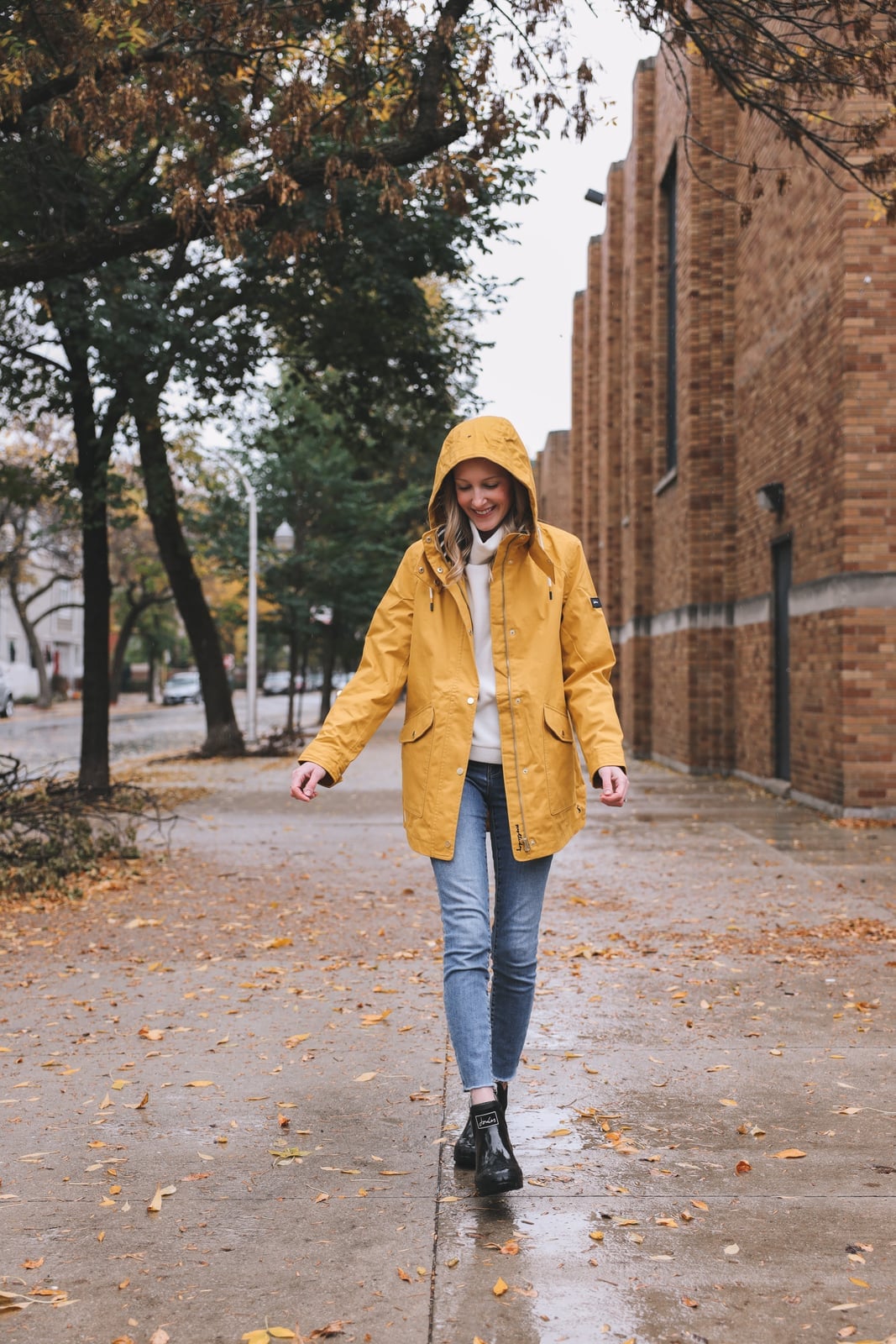 Yellow Hooded Rain Jacket Over White Turtleneck with Blue Jeans — Rain Jacket Outfits