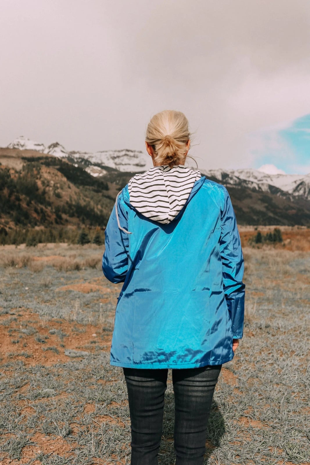 Bright Blue Jacket Over Striped T-Shirt in Natural Landscape — Rain Jacket Outfits