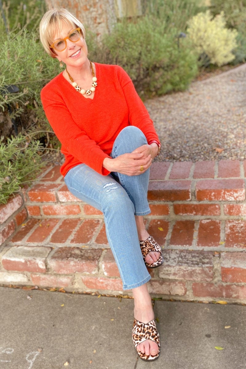 Orange-Red V-Neck Sweater With Light Wash Jeans, Close-Up Take Orange-Red V-Neck Sweater With Light Wash Jeans, Close-Up Take — Red Sweater Outfit