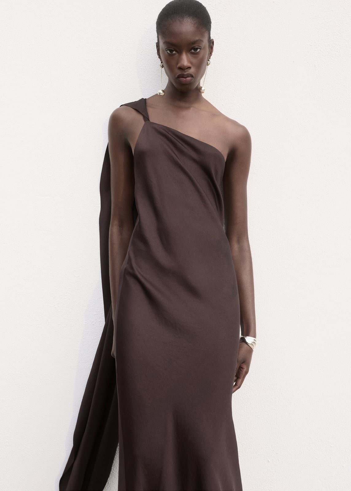 Deep Brown One-Shoulder Draped Column Dress With Hoop Earrings Deep Brown One-Shoulder Draped Column Dress With Hoop Earrings — Satin Dresses