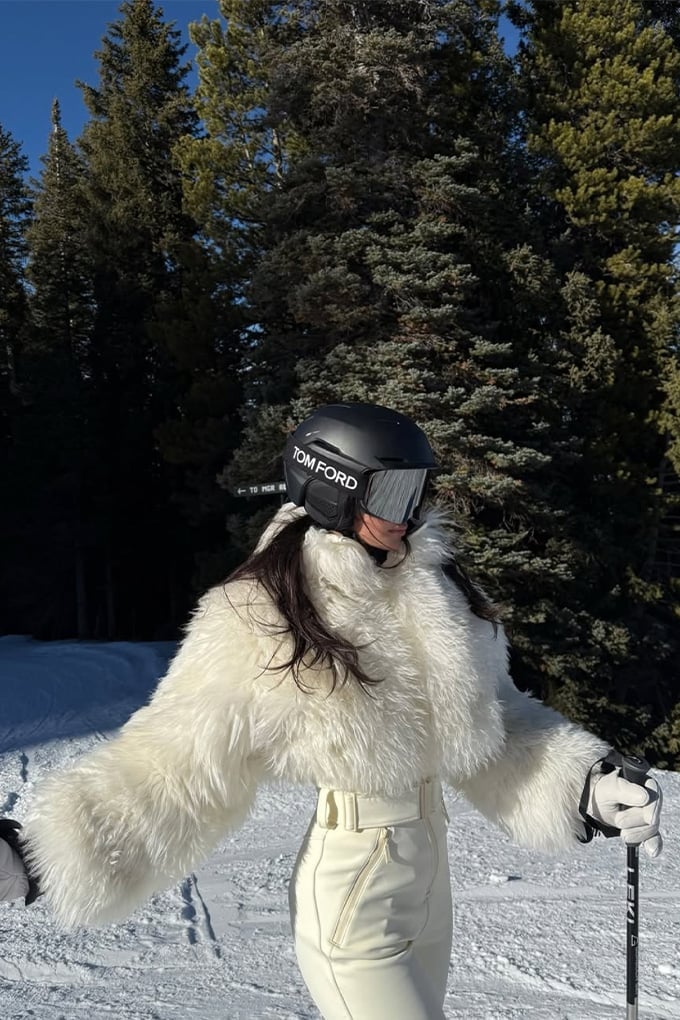 Cropped white faux fur jacket over cream ski pants — Skiing Outfit