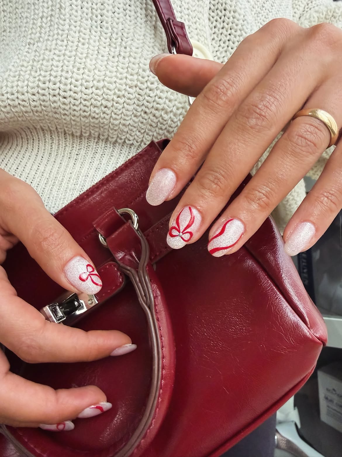 Sparkly White Nails with Red Bow Accents